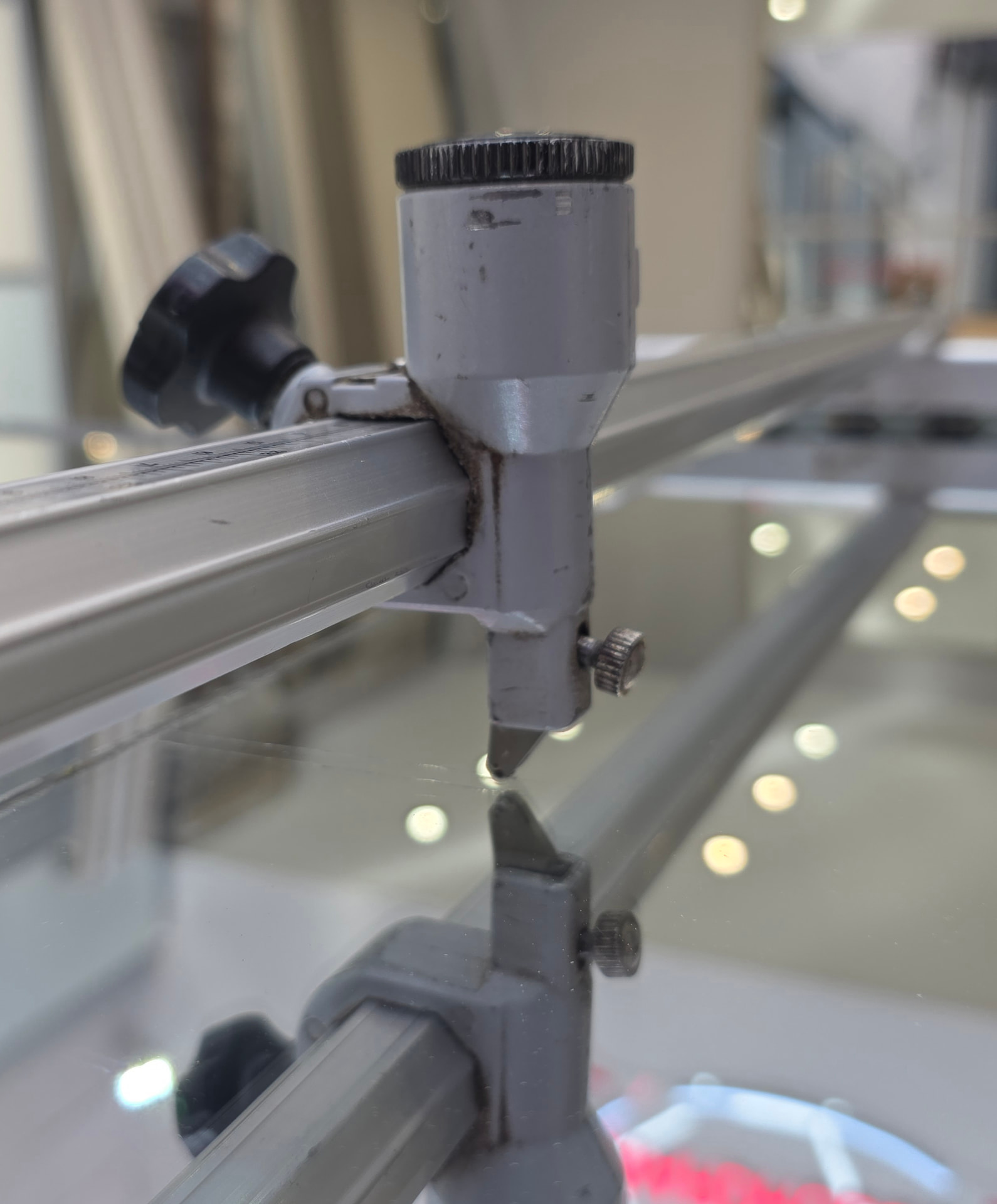 A glass cutter scoring a mirror panel on the cutting table in the Pontypridd workshop