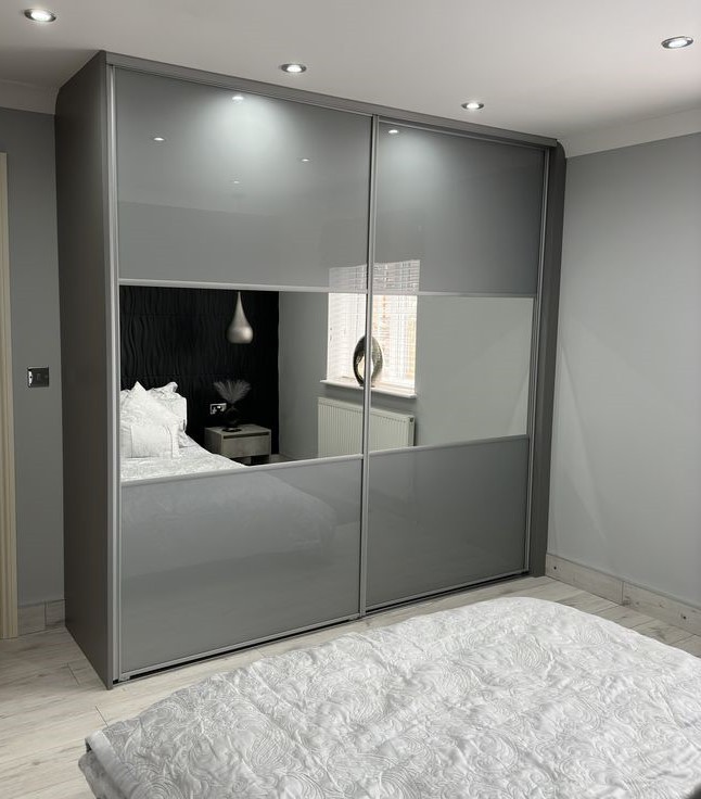 Soft grey coloured glass sliding doors with a central mirror band and silver frames in Cardiff