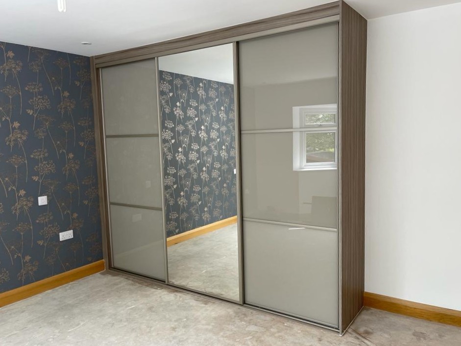 Taupe coloured glass doors with horizontal strips and a full-height central mirror in Caerphilly