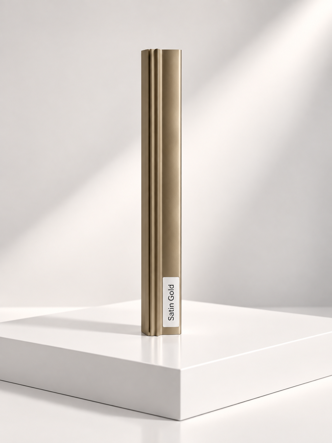 Satin gold aluminium sliding wardrobe door frame profile sample standing on a white plinth