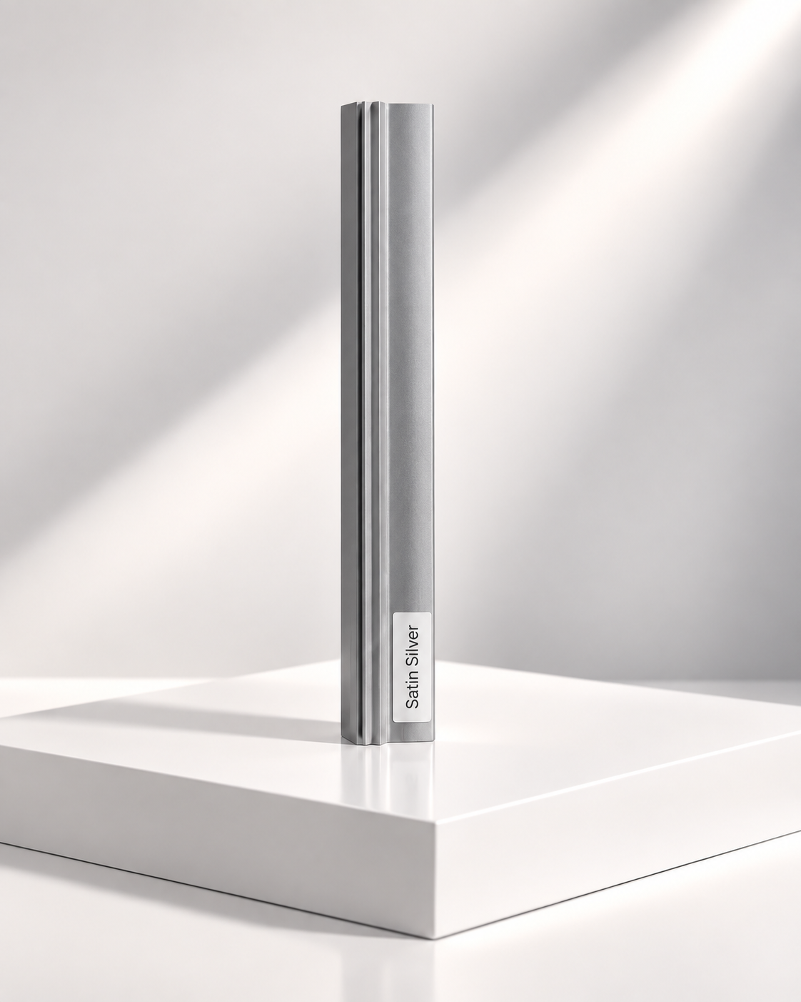 Satin silver anodised aluminium sliding wardrobe door frame profile sample standing on a white plinth