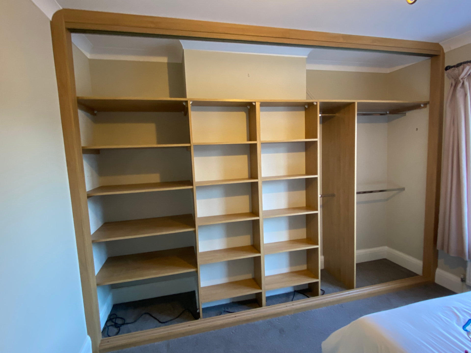 Oak shelving beside two bays of double hanging in Cardiff