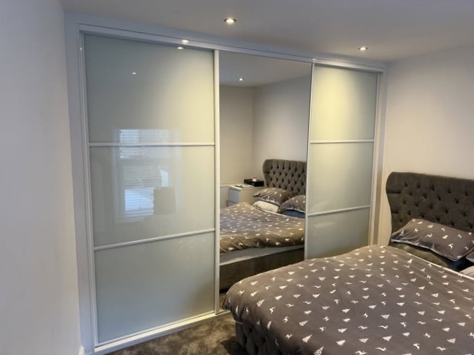 White-framed frosted glass sliding doors with a central mirror panel in Merthyr Tydfil