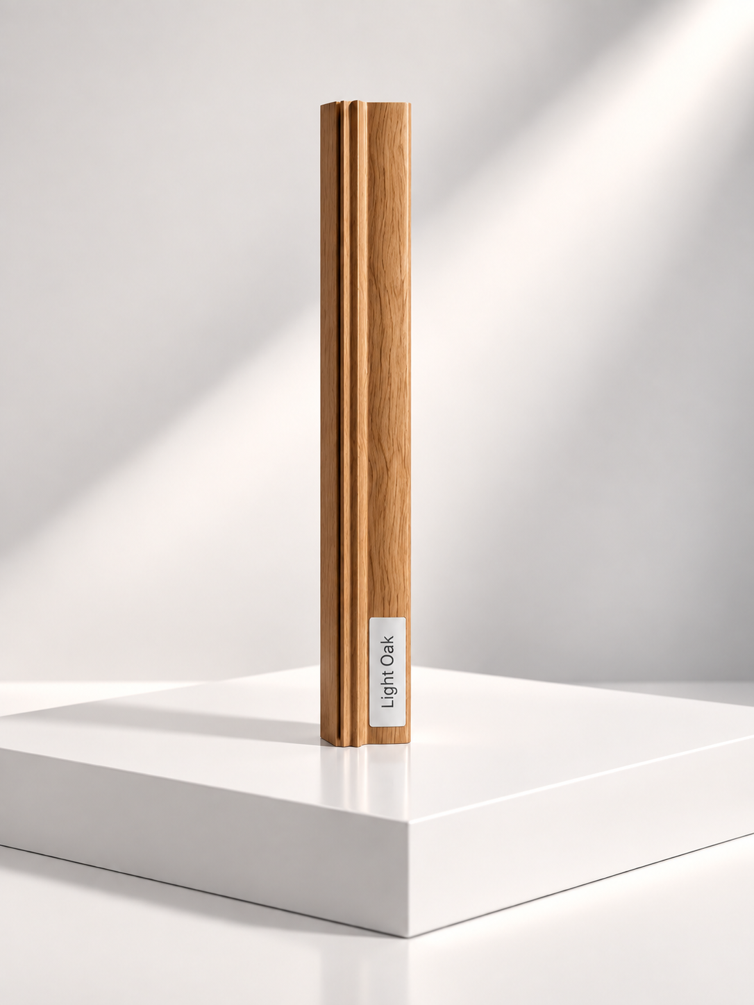 Light Oak sliding wardrobe door frame profile sample standing on a white plinth