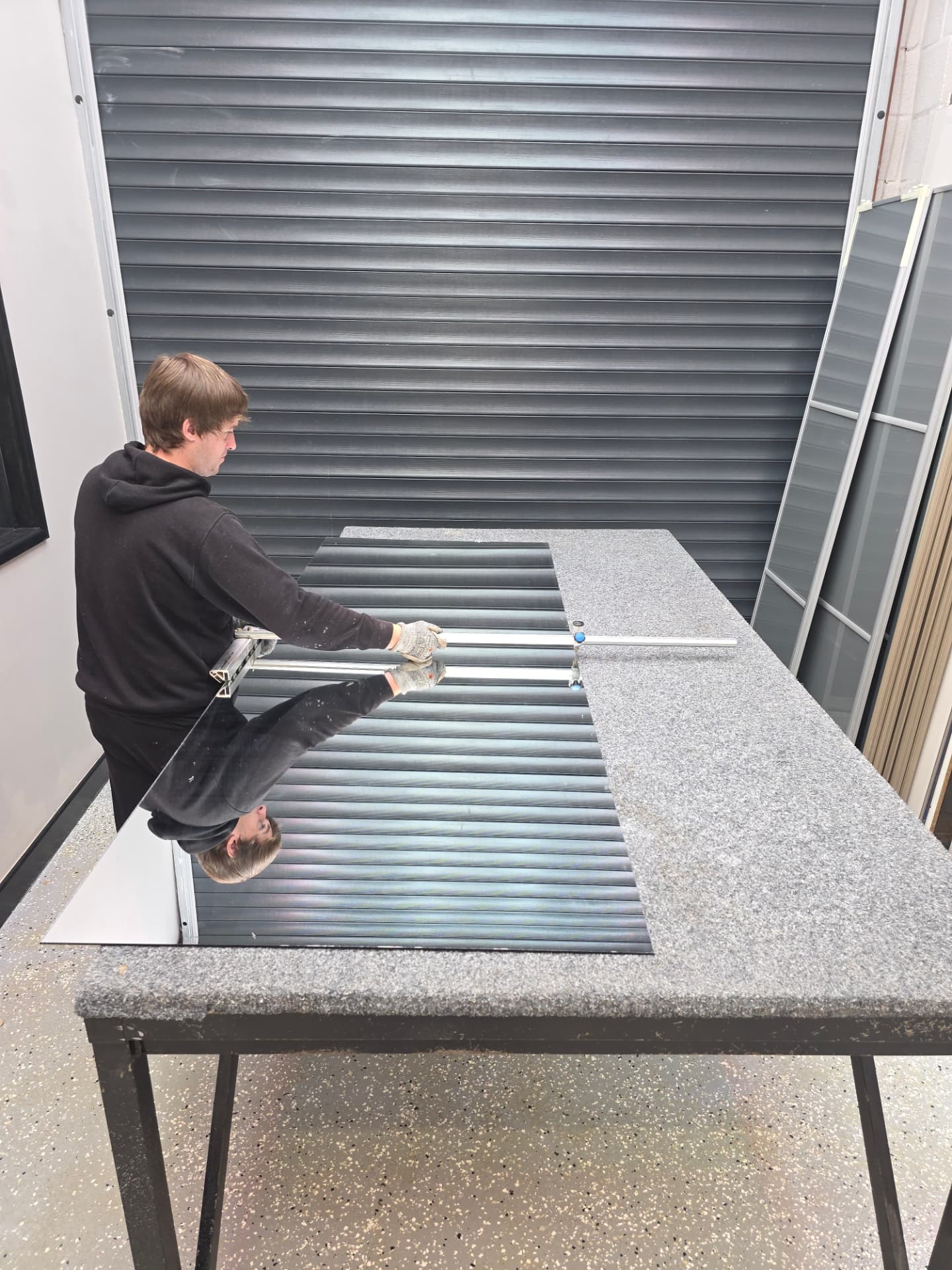 Josh working on a mirror panel at the workbench in the SP Mirror Wardrobes workshop