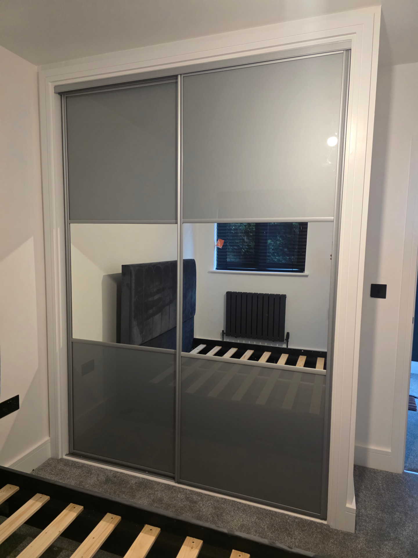 White-framed dark grey glass sliding doors with a central mirror band in Port Talbot